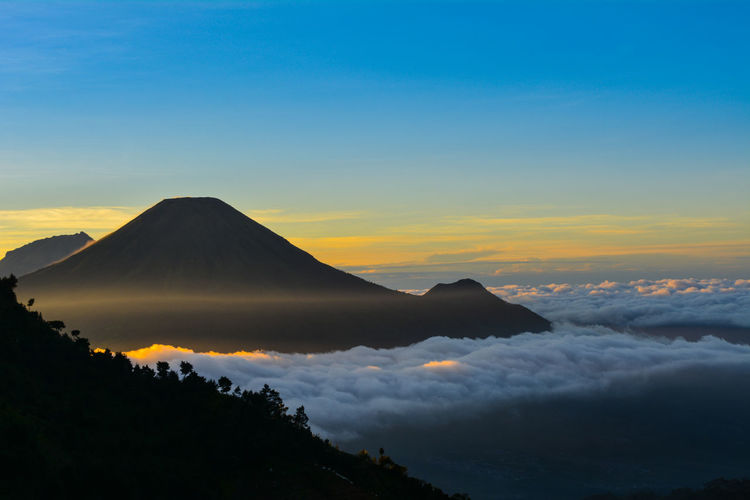 Scenic view of snowcapped mountains against sky during sunset