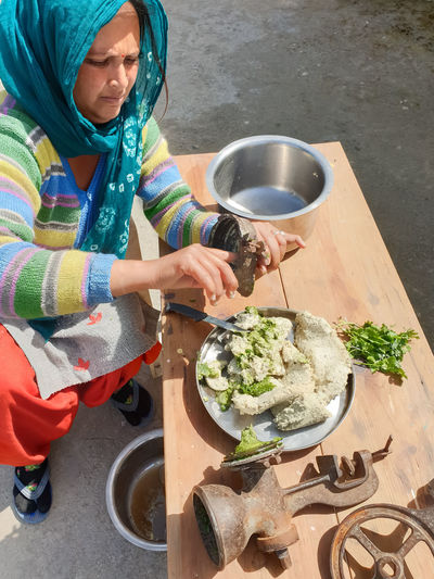 High angle view of woman holding food on table