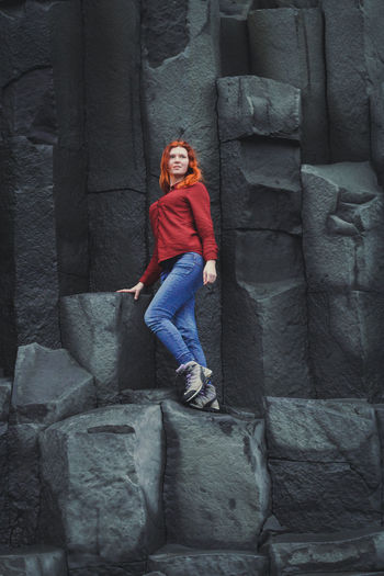 Smiling woman standing on basalt cliffs scenic photography