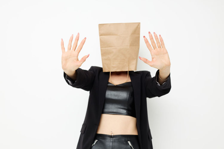 Midsection of woman holding box against white background