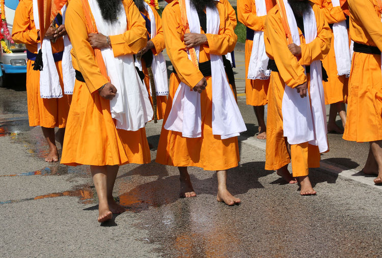 Low section of men walking on street during traditional festival