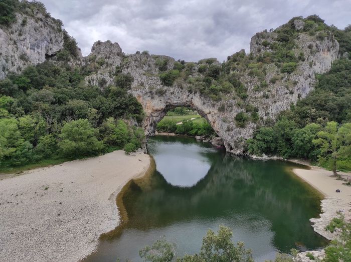Arch bridge over river against sky