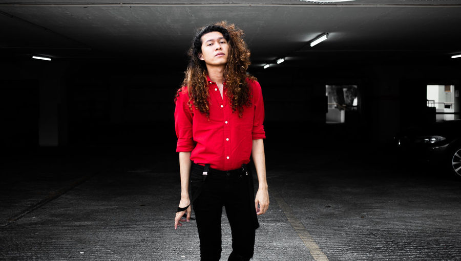 Portrait of young woman standing in parking lot