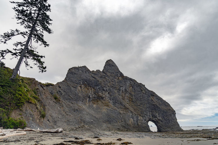 Sleeping giant rock formation on the coast of washington state under dramatic sky.