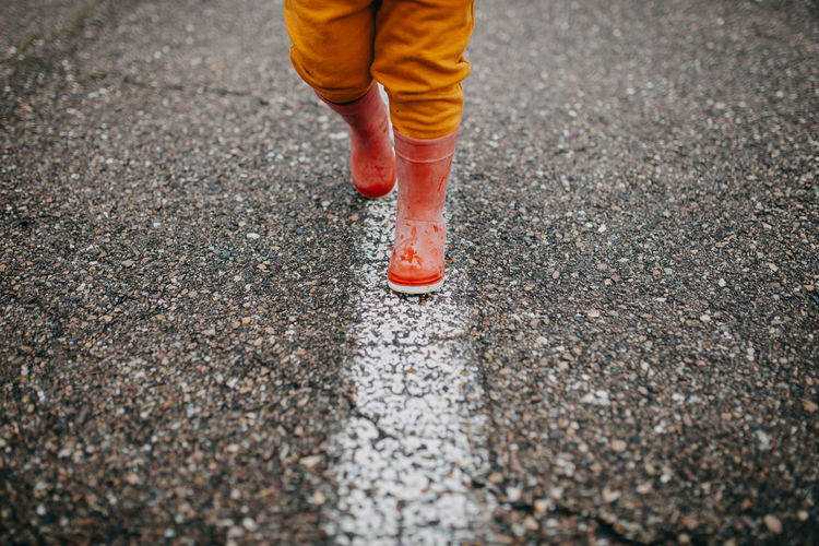 Low section of child walking on street