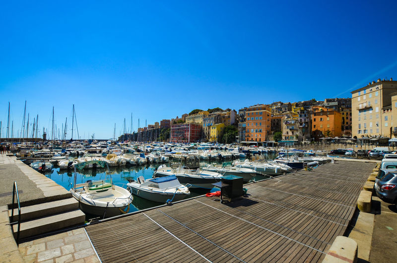 Boats moored at harbor against clear sky in bastia