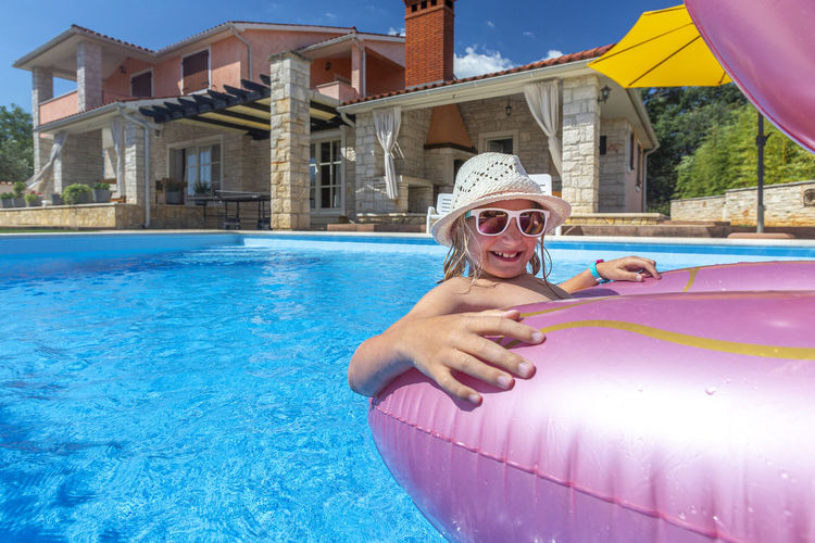 Rear view of woman with inflatable ring in swimming pool
