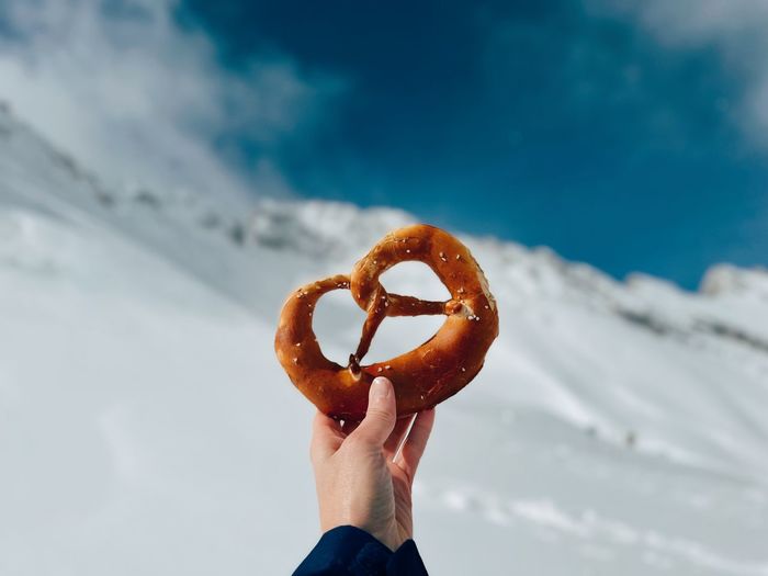 Cropped hand of woman holding pretzel