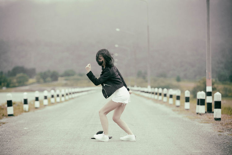 Mid adult woman posing on road