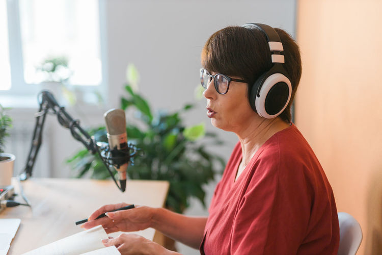 Senior woman podcasting in studio