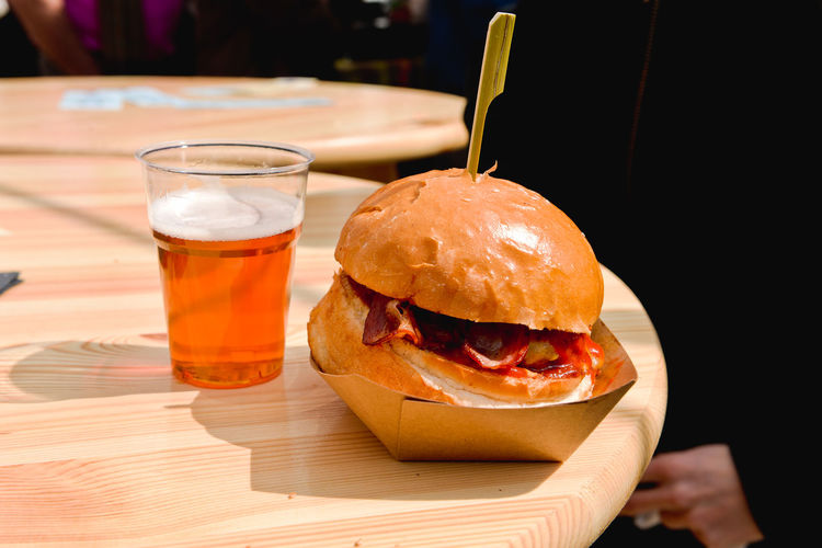 Close-up of beer glass and burger on table