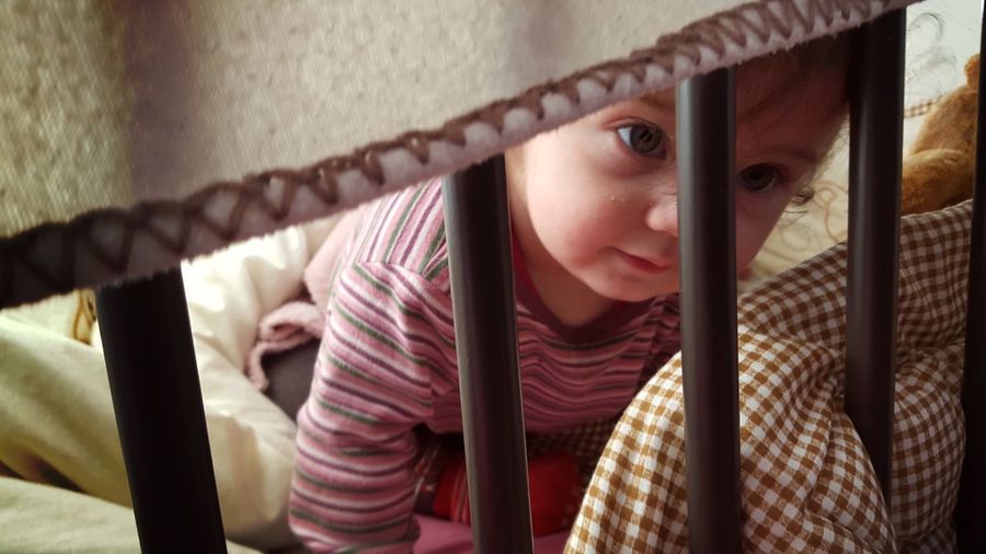 Toddler looking away while resting in crib