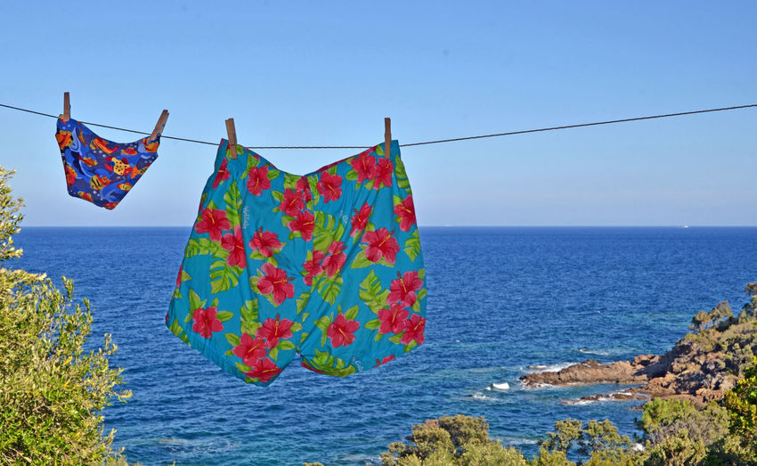 Shorts hanging on clothesline against sea