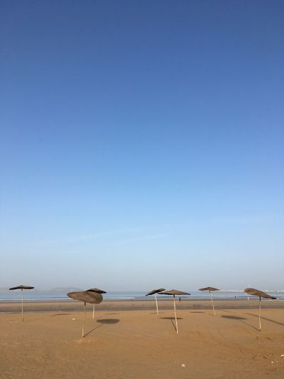 Scenic view of beach against clear blue sky