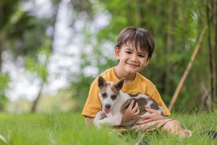 Boy sitting at park with dog