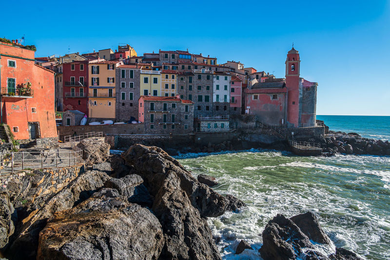 Buildings by sea against sky