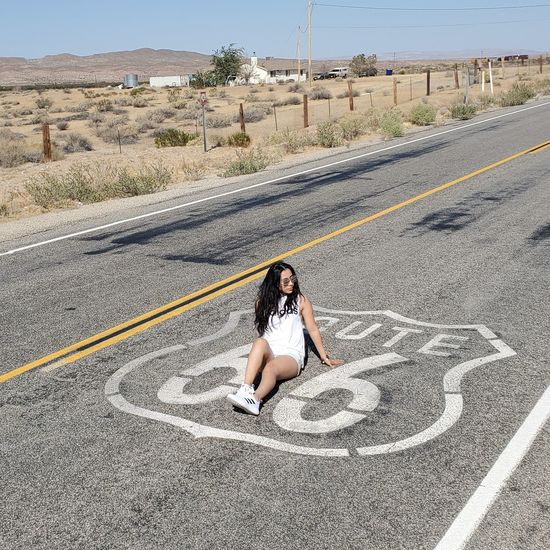 Woman sitting on road 