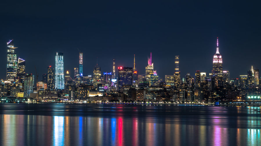 Illuminated buildings against sky at night