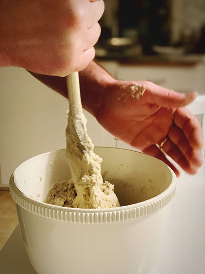 Close-up of man holding bread dough in bowl