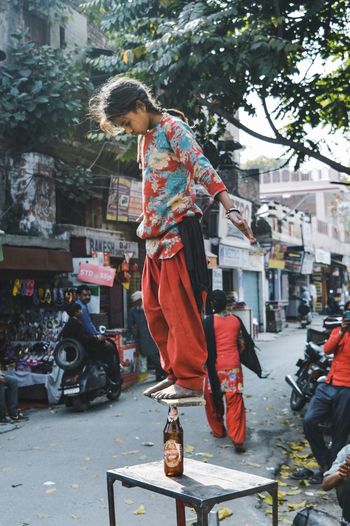 Full length of poor girl showing stunt on street