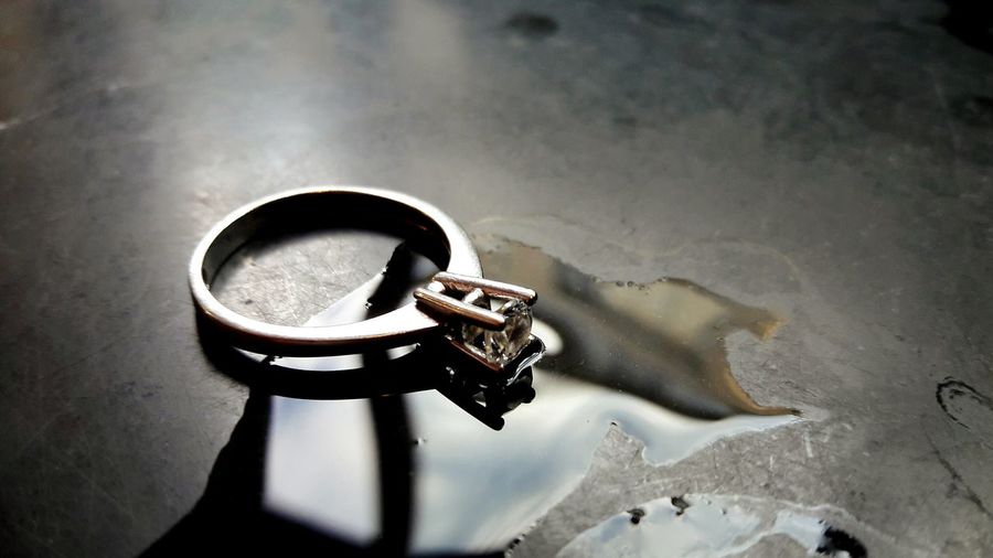 Close-up of diamond ring by water on table