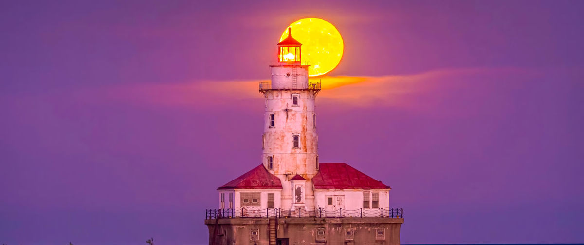 Lighthouse by sea against sky during sunset ,chicago city,usa