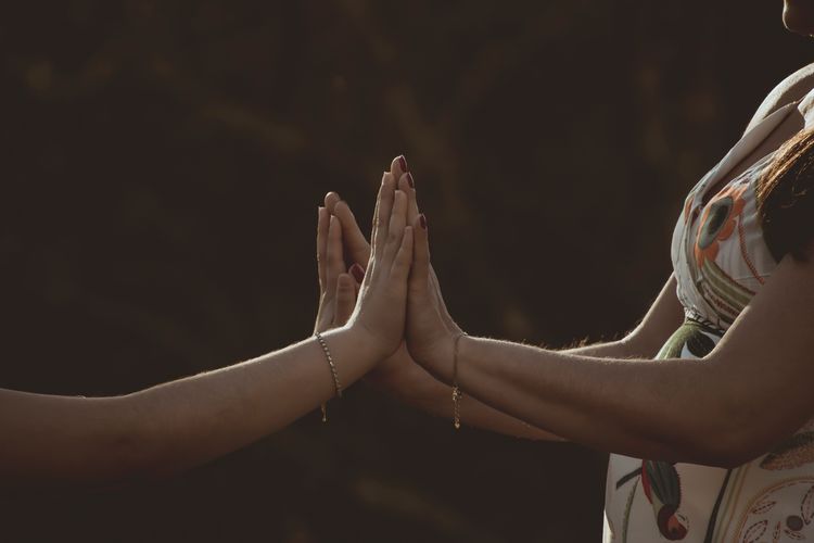 Cropped image of lesbian couple joining hands outdoors