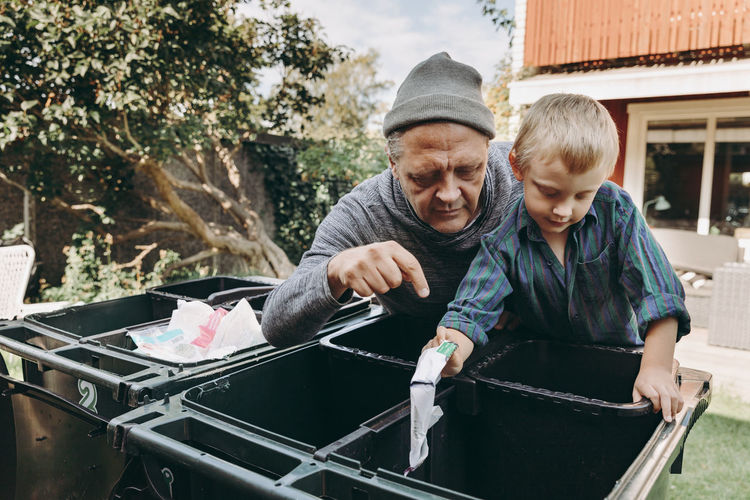 Father and son recycling waste in garden