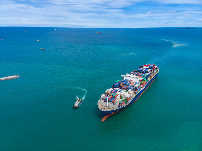 High angle view shipping containers sailing on the green sea