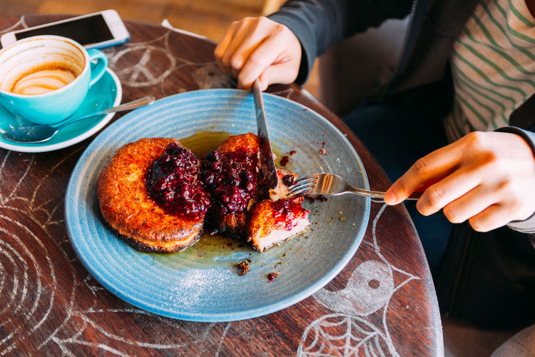 Midsection of woman having food at table