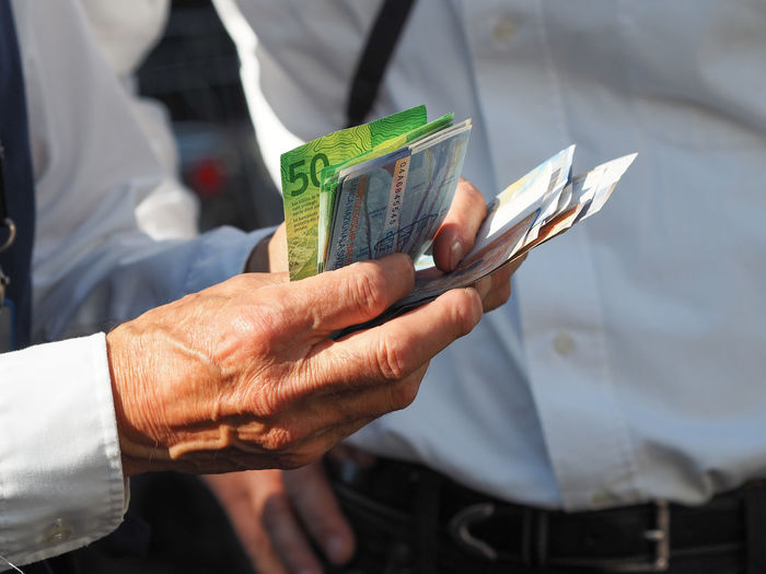 Midsection of man holding swiss currencies