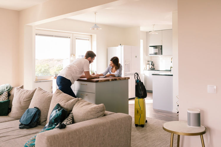 Landlord looking at tenant filling form in house rental