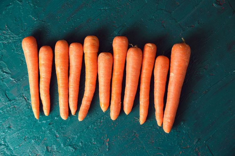 Several orange carrots on a green background