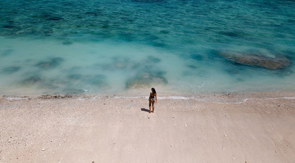 Aerial view of woman standing on beach