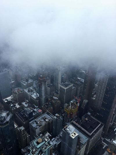 Aerial view of buildings in city during foggy weather