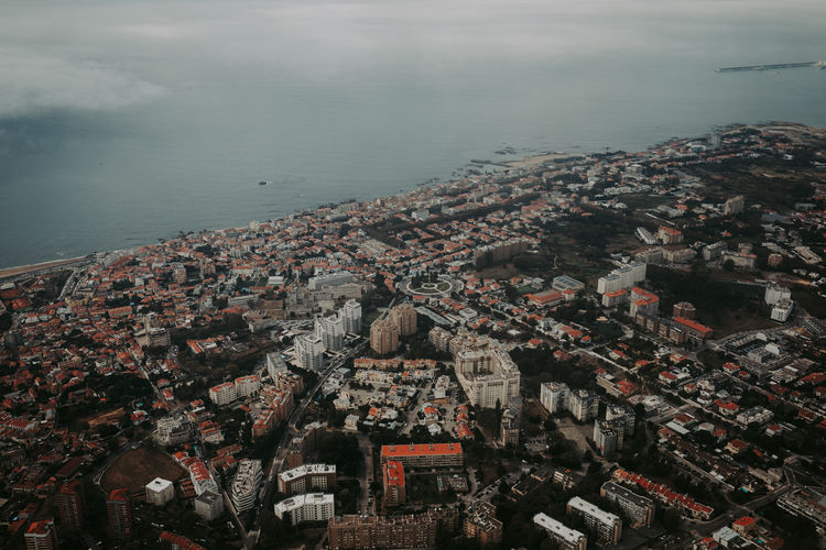 High angle view of townscape by sea against sky