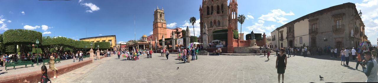 Panoramic view of people and vendors by church