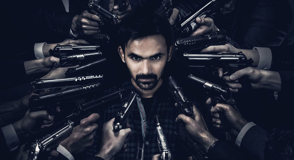 Cropped hands shooting man with handgun