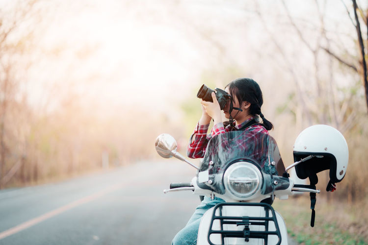 Side view of man riding motorcycle on road