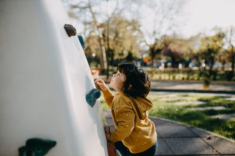 Side view of child climbing wall at playground