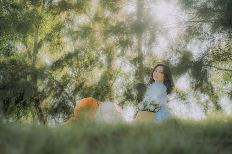 Full length of woman sitting on tree