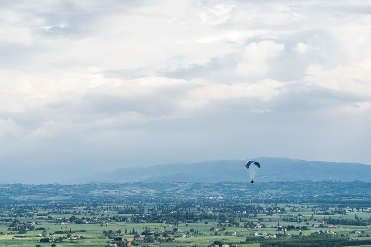 Scenic view of parachute on landscape against sky