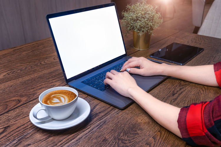Low section of woman using laptop on table