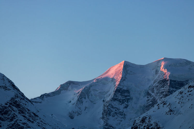 Scenic view of snowcapped mountains against clear blue sky