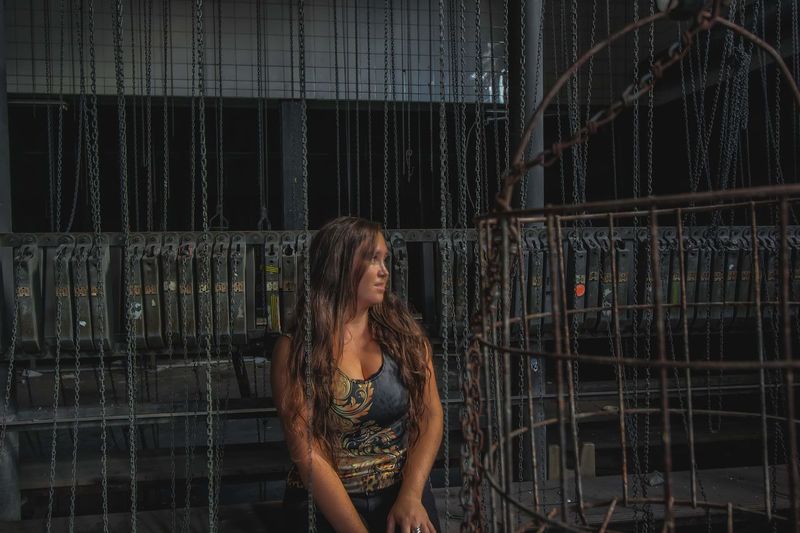 Smiling woman looking away while standing by metal