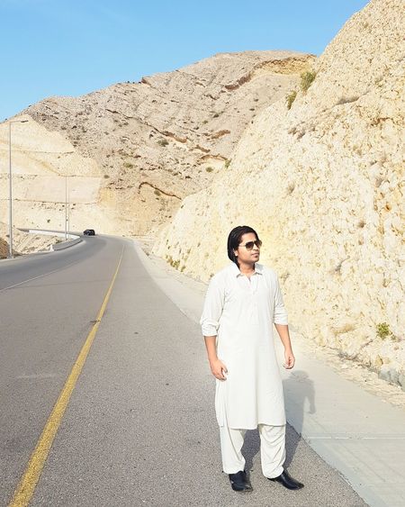 Full length of man standing on road against mountain