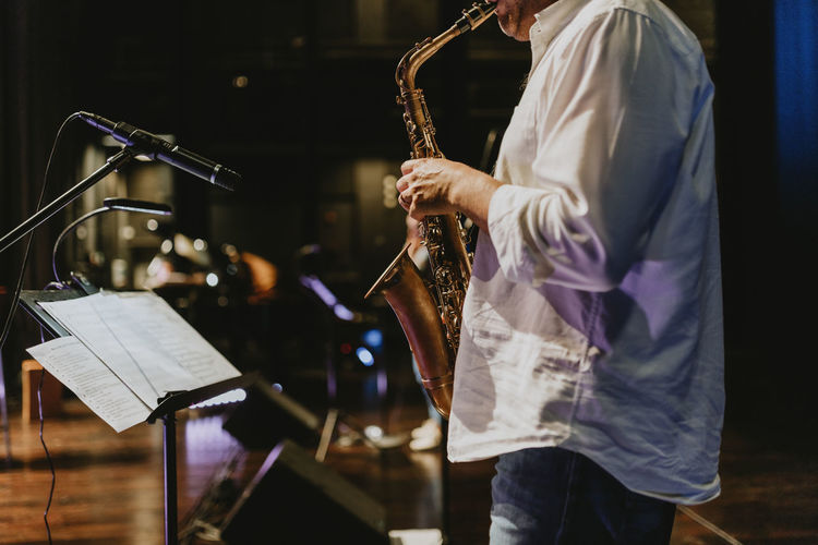 Midsection of playing saxophone at music concert