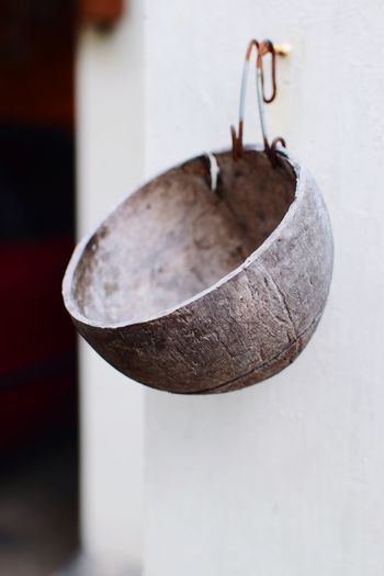Close-up of metal hanging on table against wall