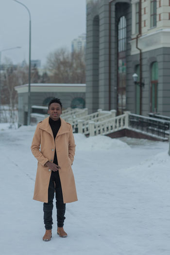 Young african american in winter against the backdrop of a majestic building