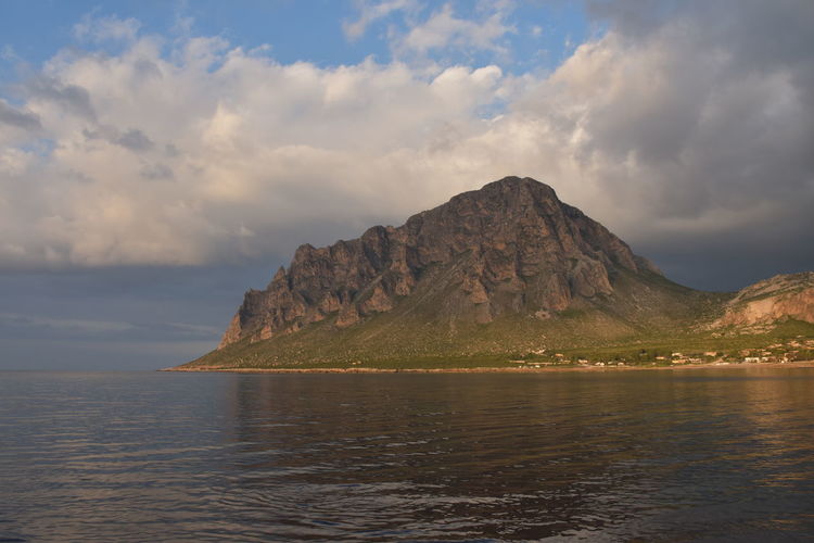Scenic view of mountain cofano, in sicily, by sea against sky